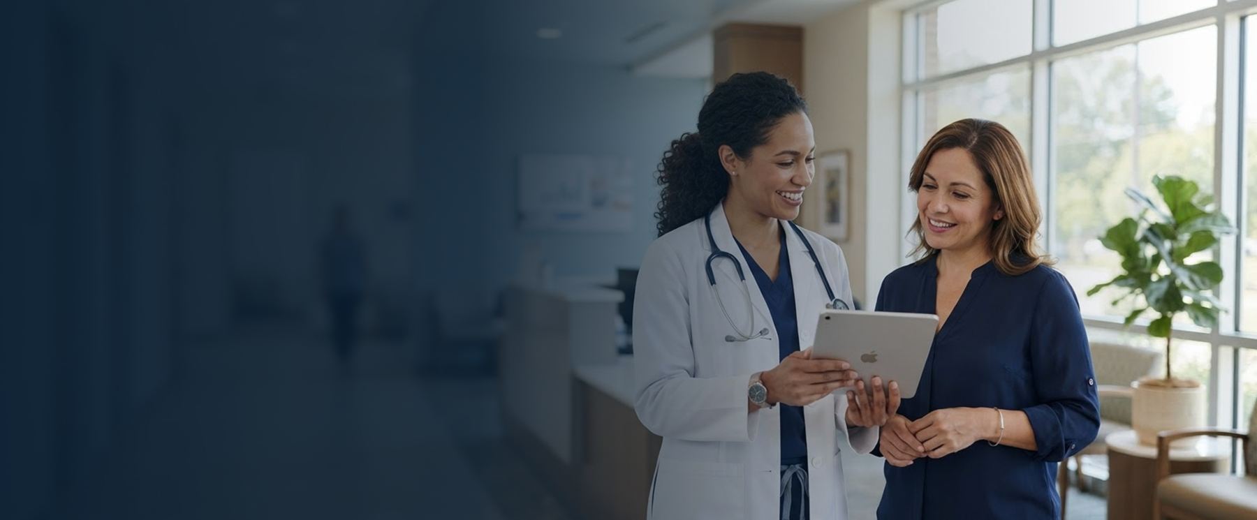 Physician reviewing information on a tablet with a practice administrator in a modern medical office